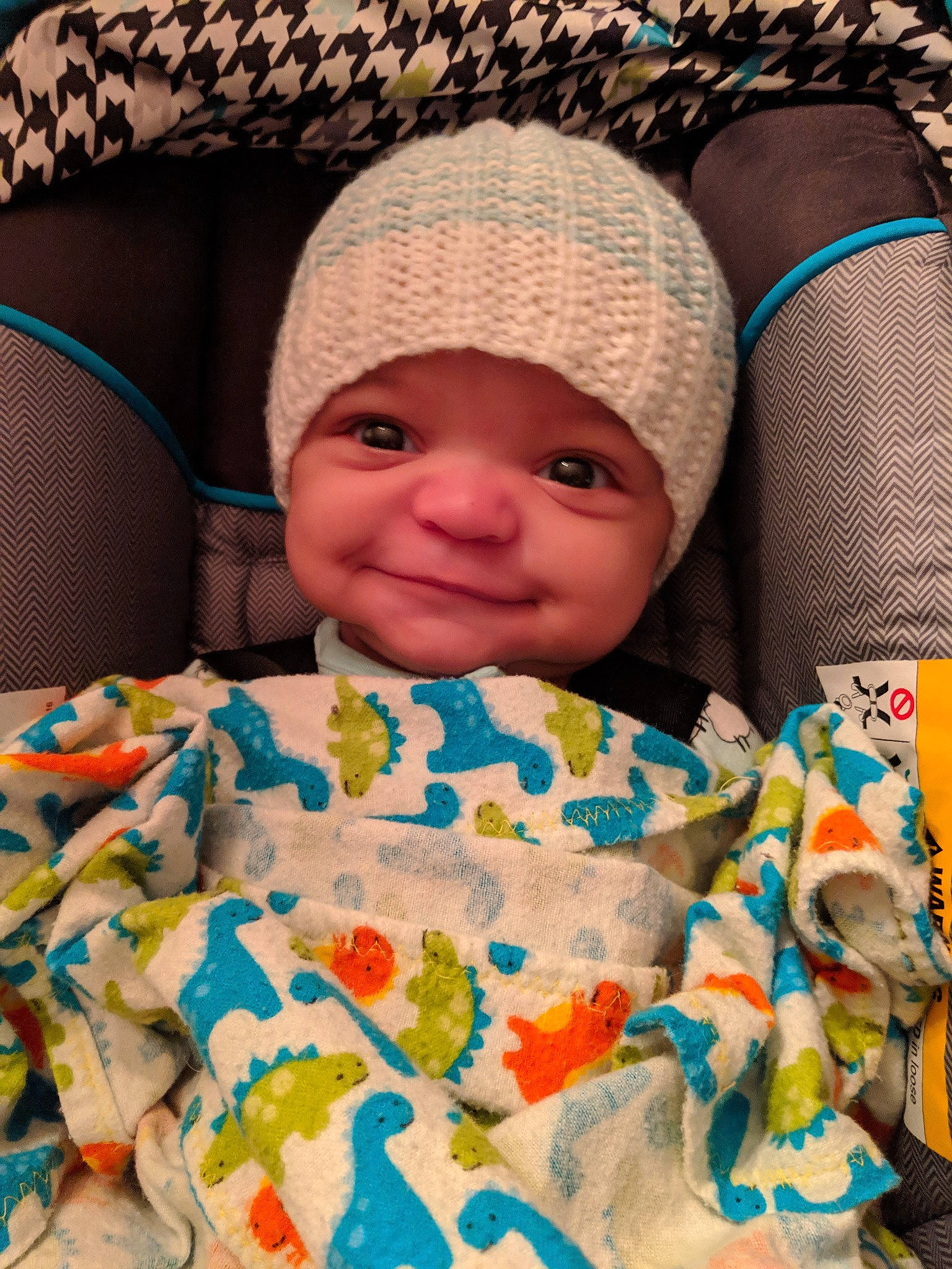 Zion is registered to the contest to win money with this photo: baby, blanket, bonnet, cheek, child, crochet, face, head, headgear, headwear, joy, knitting, linens, person, skin, smile, textile, toddler, wool