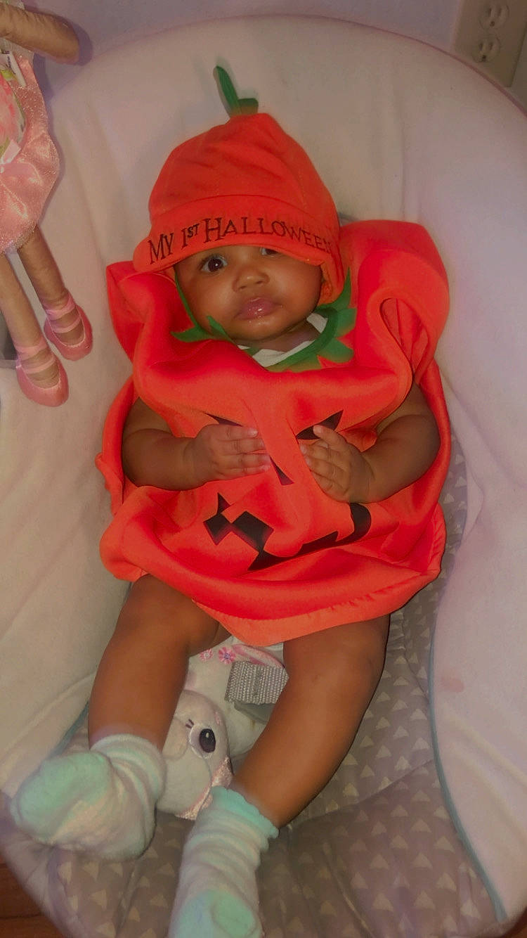 Zendaya joined the competition — help win amazing prizes! baby, baby_carriage, baby_products, baby_toddler_clothing, comfort, finger, hand, headwear, human_leg, knee, lap, linens, mouth, nail, orange, person, pink, sitting, sock, thigh