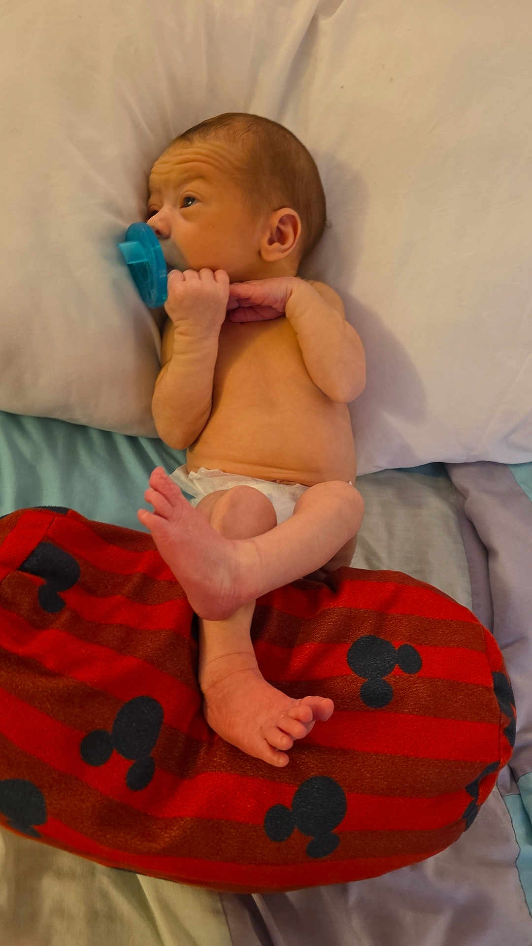 Kash joined the competition — help win amazing prizes! baby, newborn, pacifier, cushion, mickey_mouse, infant, bed, blanket, skin, feet, hand, head, sleeping_area, resting, child, indoors, soft, comfort, cute, small