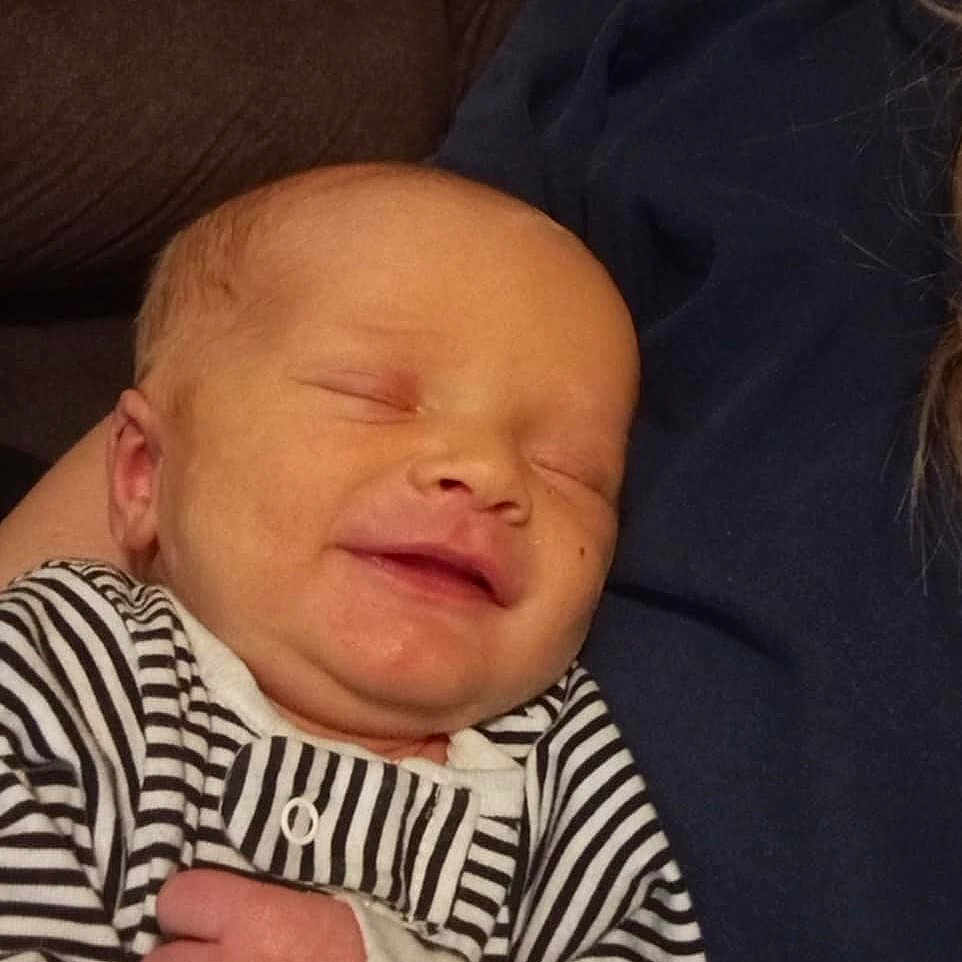 Finn joined the competition — help win amazing prizes! baby, clothing, couch, cushion, face, furniture, glove, happy, head, homedecor, indoors, laughing, newborn, person, photography, portrait, quilt, sleeping, smile, t_shirt
