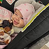 Kiara joined the competition — help win amazing prizes! baby, smiling, car_seat, pink_hat, blanket, bottle, infant, cute, indoors, child, warm_clothing, face, headwear, happy, person, baby_accessory, seat, baby_bottle, cozy, infant_care