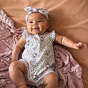 Kiara joined the competition — help win amazing prizes! arm, baby, blanket, child, chubby, cozy, cute, face, happy, headband, hello_kitty, indoors, infant, leg, lying_down, onesie, pink, skin, smiling, soft_texture