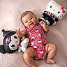 Kiara joined the competition — help win amazing prizes! baby, infant, smiling, hello_kitty, plush_toy, stuffed_animal, pink_onesie, soft_blanket, cute, child, happy, indoor, portrait, chubby_cheeks, playful, lying_down, toddler, hand, foot, cozy