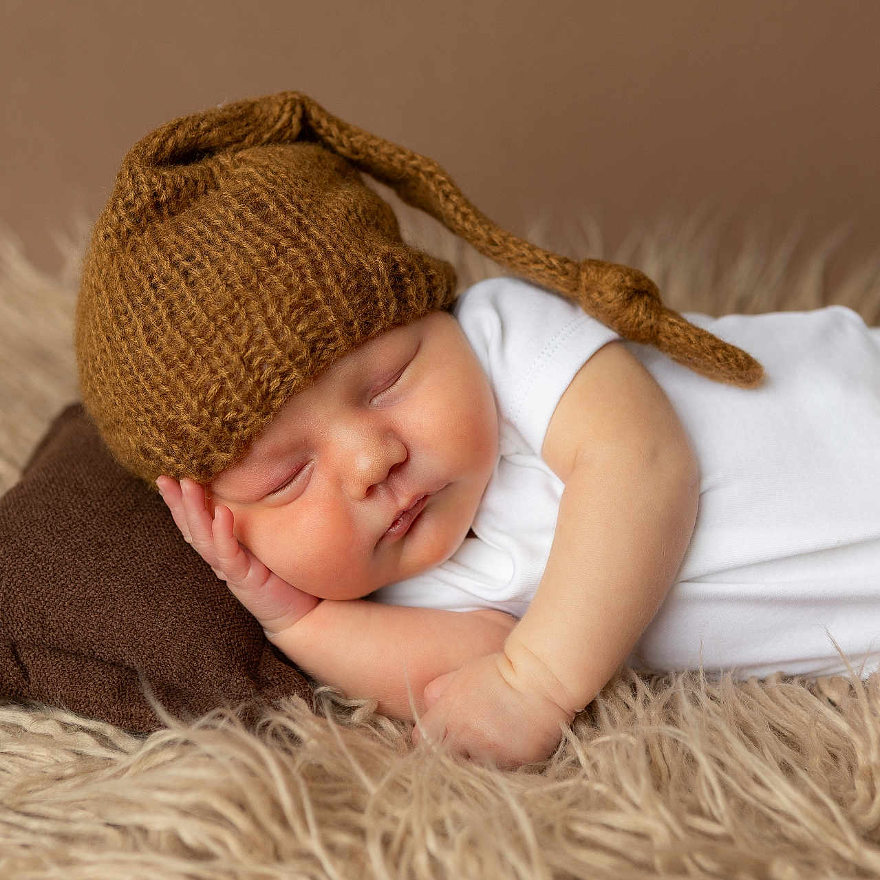 Jordan joined the competition — help win amazing prizes! baby, brown, child, closeup, cozy, cute, fluffy_rug, hat, indoors, infant, knitted_hat, newborn, peaceful, pillow, portrait, resting, sleep, sleeping, soft_texture, white_onesie