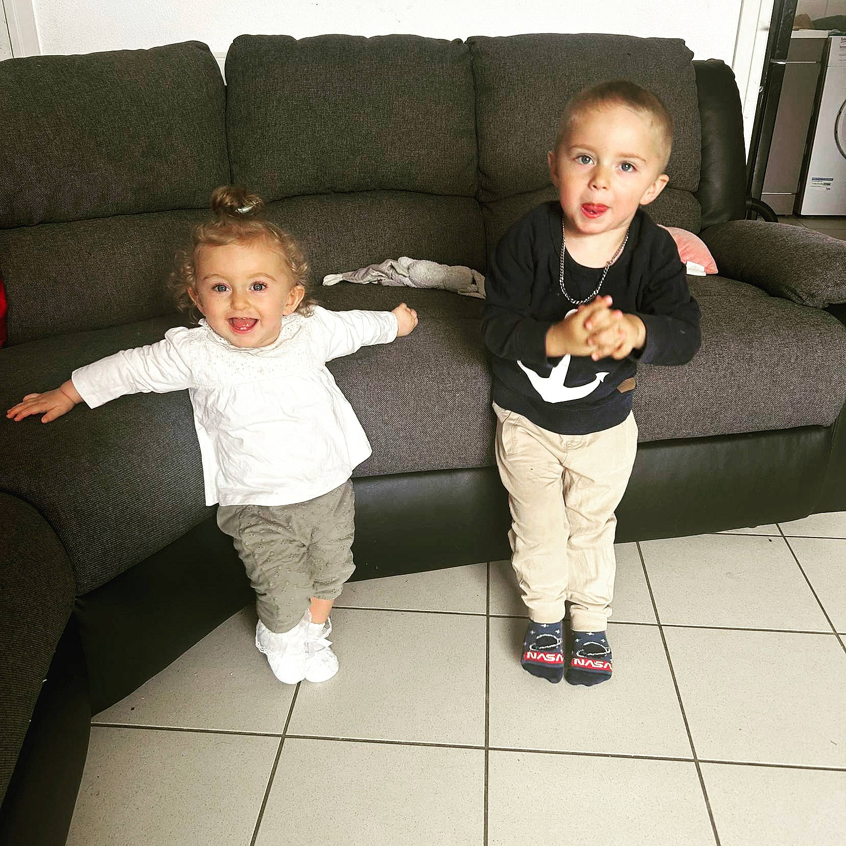 Zélie participe au concours pour gagner de l'argent avec cette photo : baby_toddler_clothing, black, child, comfort, couch, face, floor, flooring, fun, furniture, gesture, happy, joy, leg, living_room, person, sharing, sleeve, smile, snapshot