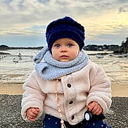 Rose a rejoint le concours — aidez-le/la à gagner de superbes lots ! toddler, child, baby, hat, scarf, coat, pacifier, keychain, outdoor, harbor, boats, water, cloudy_sky, stone_wall, winter_clothes, blue_eyes, curious, cold_weather, seaside, nature