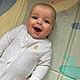 baby, infant, smiling, white_onesie, embroidery, duck, play_mat, colorful, fish, aquatic, child, happy, cute, portrait, indoors, face, hand, skin, head, expression