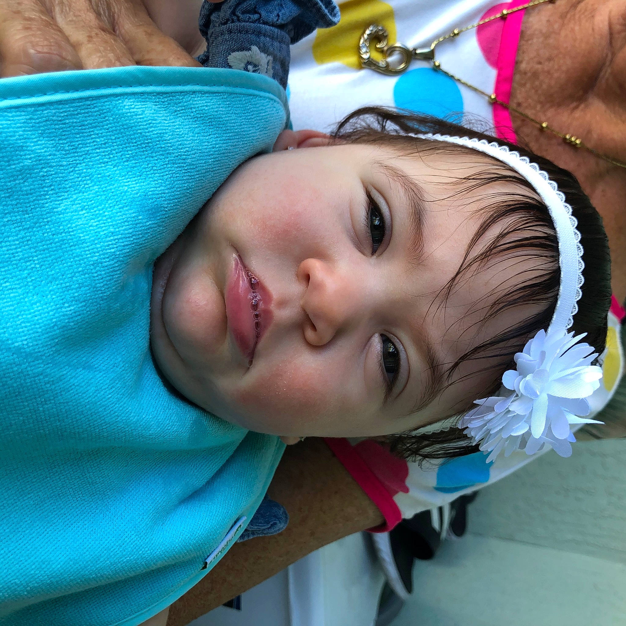 Daphne is registered to the contest to win money with this photo: azure, baby, blue, chest, child, electric_blue, event, eyelash, fashion_accessory, flower, fun, happy, headgear, headpiece, leisure, lip, organ, person, skin, smile