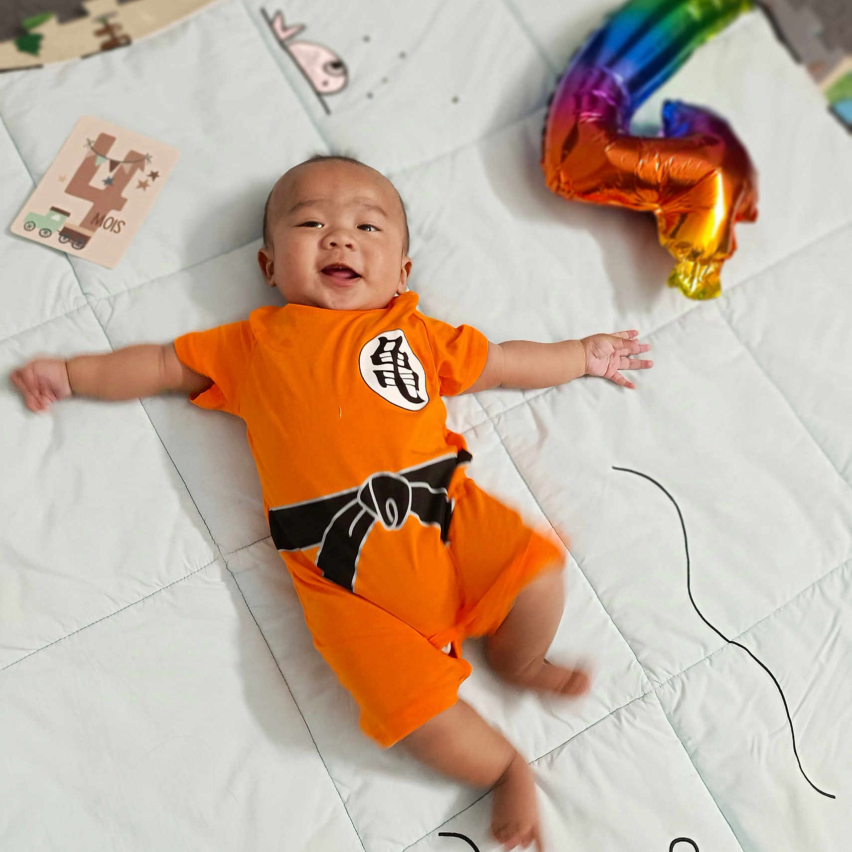Jirou participe au concours pour gagner de l'argent avec cette photo : applique, baby, balloon, bed, bedroom, bodypart, clothing, face, finger, furniture, hand, happy, head, indoors, pattern, person, photography, portrait, purple, t_shirt