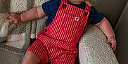 Luca joined the competition — help win amazing prizes! baby, child, smiling, overalls, red_striped, navy_shirt, white_socks, armchair, textured_fabric, cozy, indoor, happy, cute, infant, portrait, seated, furniture, skin, head, hand