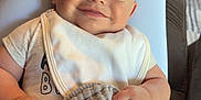 Luca is registered to the contest to win money with this photo: baby, bib, blanket, carpet, child, clothing, comfort, cute, face, footwear, furniture, happy, home, indoor, person, portrait, relaxing, seated, smiling, texture