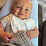 Luca is registered to the contest to win money with this photo: baby, smiling, blanket, bib, indoor, child, clothing, person, face, happy, seated, comfort, texture, home, furniture, carpet, footwear, relaxing, cute, portrait