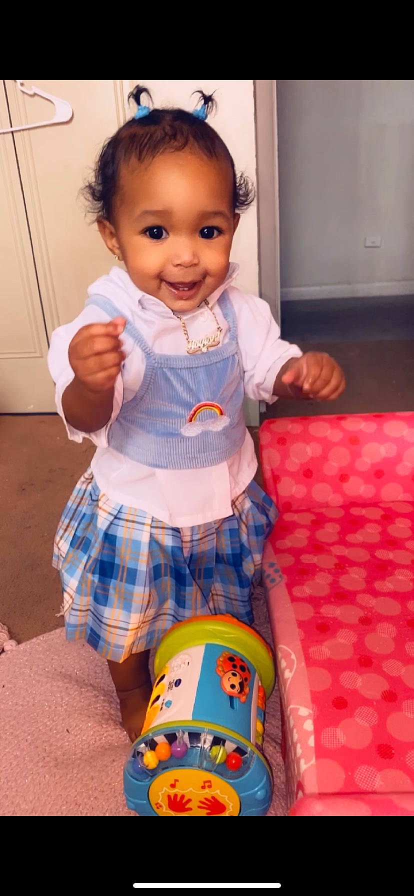 Naylani is registered to the contest to win money with this photo: baby, baby_playing_with_toys, baby_toddler_clothing, cheek, child, clothing, happy, human_body, joy, organ, pattern, person, pink, plaid, skin, sleeve, smile, sock, t_shirt, tartan