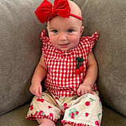 Kailani is registered to the contest to win money with this photo: baby, child, infant, sitting, portrait, smiling, bow, headband, red, gingham, outfit, cherries, fruit_pattern, couch, indoor, face, eyes, happy, fashion, photography