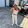 child, girl, sunglasses, white_outfit, pink_flower, outdoor, sunlight, shadows, pavement, building, car, playful_pose, happy, fashion, casual, street, person, young, smiling, daytime