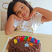 Louyse participe au concours pour gagner de l'argent avec cette photo : child, birthday, cake, chocolate, candles, smile, happy, long_hair, white_shirt, table, celebration, party, colorful, posing, indoor, food, dessert, cute, face, hands