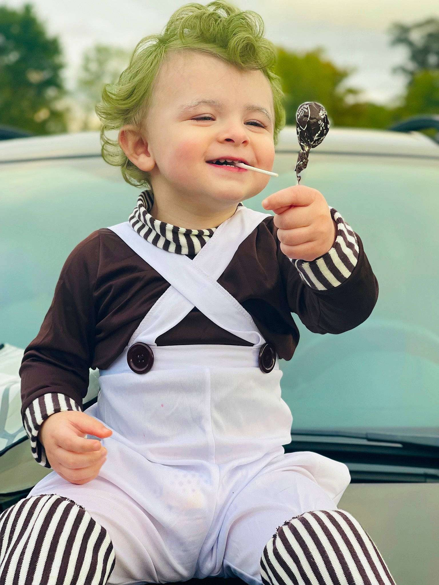 Clayton is registered to the contest to win money with this photo: automotive_design, automotive_exterior, blond, car, child, dress, family_car, gesture, grass, hairstyle, happy, hood, joy, luxury_vehicle, motor_vehicle, person, sleeve, smile, t_shirt, toddler