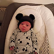 Theodore is registered to the contest to win money with this photo: baby, bassinet, bedding, bedroom, blanket, child, clothing, cute, eyes, face, hat, indoors, infant, lying_down, mickey_mouse, mouse_ears, newborn, onesie, photography, portrait