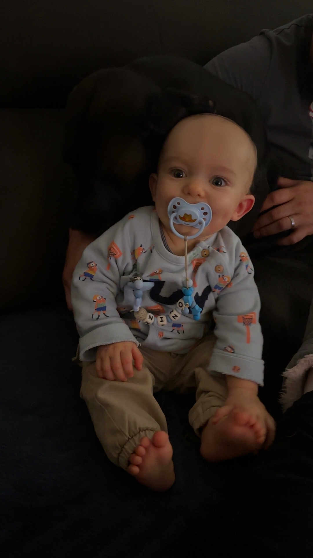 Nino a rejoint le concours — aidez-le/la à gagner de superbes lots ! baby, barefoot, child, clothing, comfort, couch, cute, dog, face, hand, home, indoor, pacifier, pants, person, pet, relaxation, sitting, smile, toy