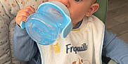 Nino a rejoint le concours — aidez-le/la à gagner de superbes lots ! baby, bib, blue, child, clothing, cute, drinking, expression, face, floor, furniture, green, high_chair, home, indoor, person, seat, sippy_cup, toy, wood
