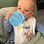 Nino a rejoint le concours — aidez-le/la à gagner de superbes lots ! baby, child, high_chair, sippy_cup, bib, indoor, furniture, drinking, face, person, cute, expression, clothing, seat, toy, blue, green, wood, floor, home