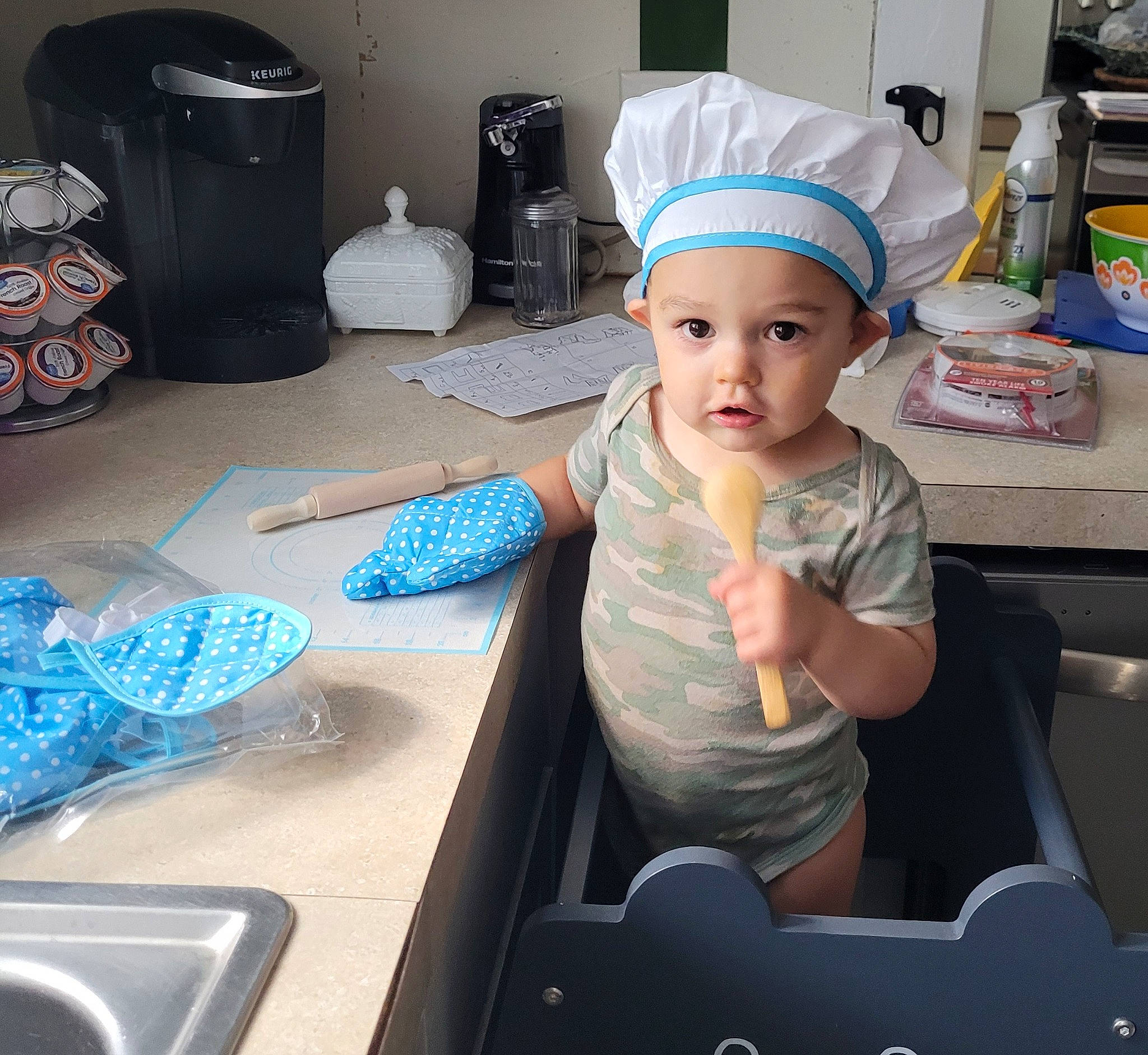 Archer is registered to the contest to win money with this photo: baby, baby_toddler_clothing, baseball_cap, cap, child, electric_blue, fashion_accessory, fun, hat, headwear, person, personal_protective_equipment, play, room, sitting, t_shirt, table, toddler