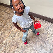 Imani is registered to the contest to win money with this photo: child, girl, smiling, standing, white_shirt, denim_jeans, red_shoes, braided_hair, beads, purse, red_purse, floor_tiles, indoor, happy, cute, fashion, playful, person, casual, portrait