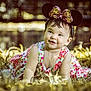 baby, child, infant, flowered_dress, headband, minnie_mouse_ears, grass, outdoor, sunlight, smiling, happy, crawling, nature, portrait, cute, accessory, jewelry, earrings, golden_light, bokeh