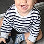 baby, child, smiling, striped_shirt, socks, floor, crawling, happy, indoor, person, blue_eyes, tooth, hand, cute, toddler, wooden_floor, clothing, striped_socks, holding_object, playful