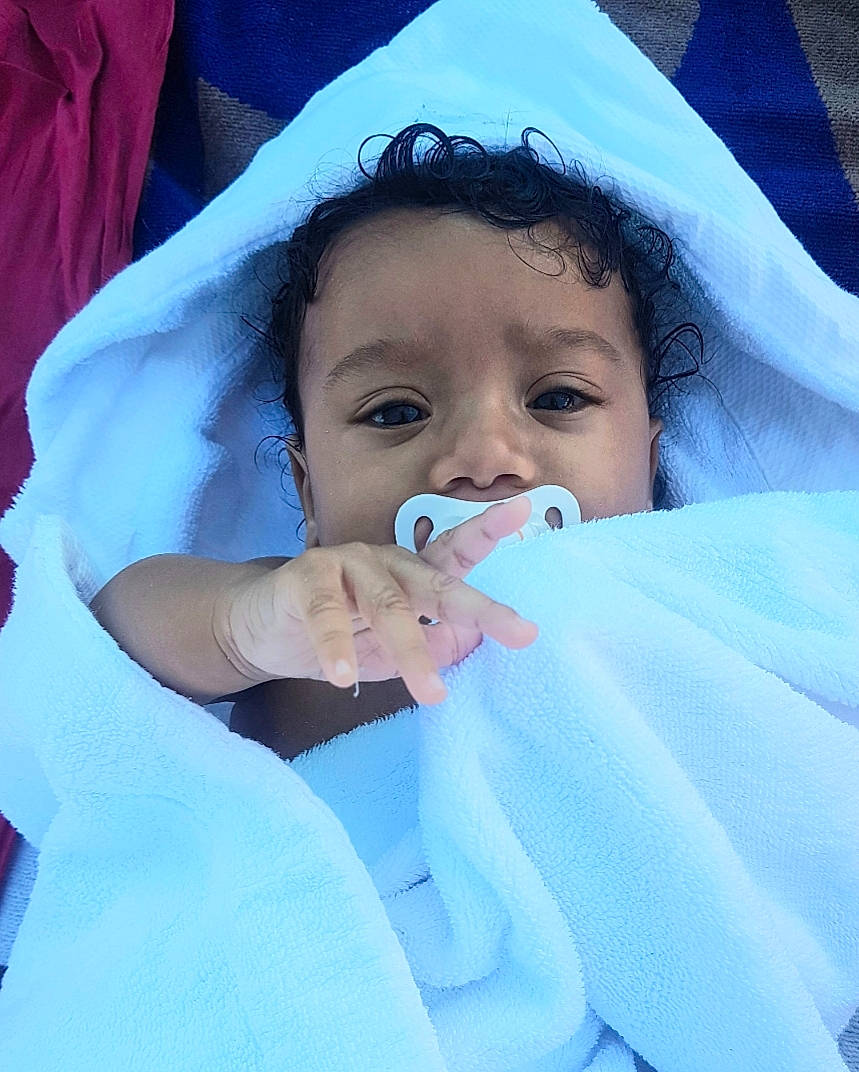 Meloah participe au concours pour gagner de l'argent avec cette photo : baby, baby_toddler_clothing, cheek, child, chin, comfort, eyebrow, eyelash, finger, gesture, hand, happy, iris, linens, lip, mouth, nose, person, skin, sleeve