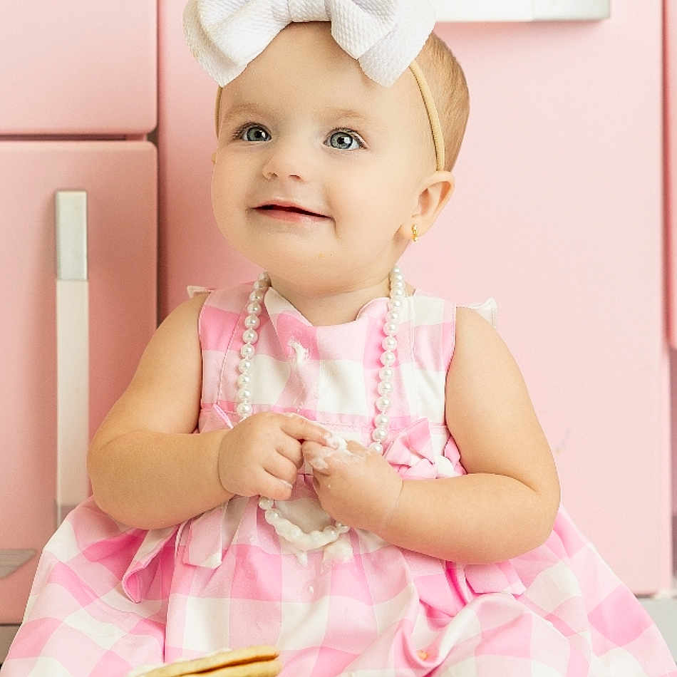 Aspyn is registered to the contest to win money with this photo: apparel, baby, bow_headband, child, cute, face, floor, food, girl, happy, headband, indoors, kitchen, messy_hands, pancakes, pearl_necklace, pink_dress, portrait, sitting, smiling