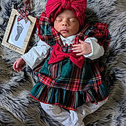 Aurelia is registered to the contest to win money with this photo: baby, newborn, sleeping, plaid_dress, red_bow, headband, white_clothing, fur_blanket, footprint_frame, wooden_frame, hand, infant, cozy, holiday, portrait, soft_texture, cute, peaceful, indoors, lying_down