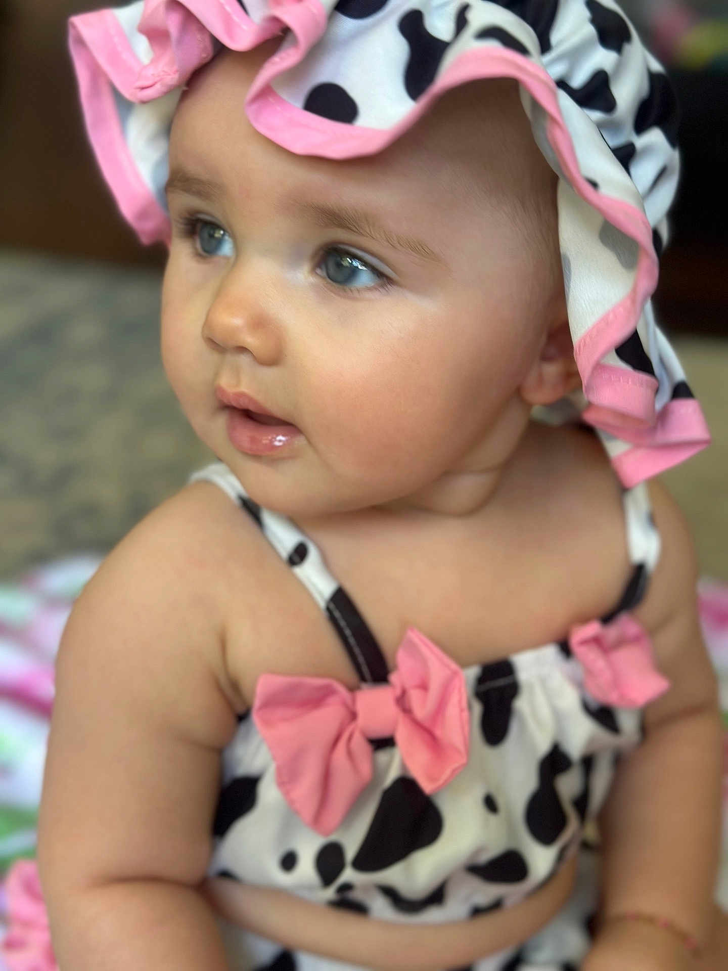 Lydia is registered to the contest to win money with this photo: baby, child, face, blue_eyes, pink_bow, cow_print, hat, cute, portrait, skin, innocent, closeup, soft_focus, clothing, infant, adorable, person, smile, cheeks, sitting