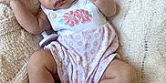 Lydia is registered to the contest to win money with this photo: baby, sleeping, infant, pink_headwrap, floral_outfit, socks, blanket, cute, peaceful, soft_texture, cozy, child, toddler, resting, indoors, portrait, adorable, comfort, relaxation, newborn