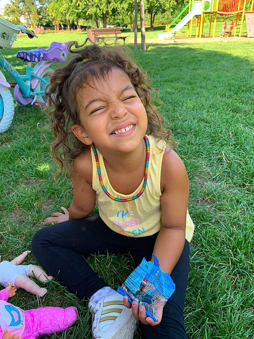 Alyah participe au concours pour gagner de l'argent avec cette photo : child, event, fun, grass, green, happy, joy, lawn, leisure, people_in_nature, person, pink, plant, recreation, sitting, skin, smile, sock, summer, thigh