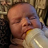 Roselynn is registered to the contest to win money with this photo: baby, newborn, infant, bottle, feeding, sleepy, face, portrait, indoors, blanket, clothing, bed, bedding, curtains, home, close_up, sitting, resting, candid, photography