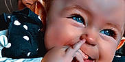 Maia participe au concours pour gagner de l'argent avec cette photo : baby, babylaughing, biting, bodypart, clothing, dress, eating, face, finger, food, glove, hand, happy, head, mouth, person, photography, portrait, smile, teeth