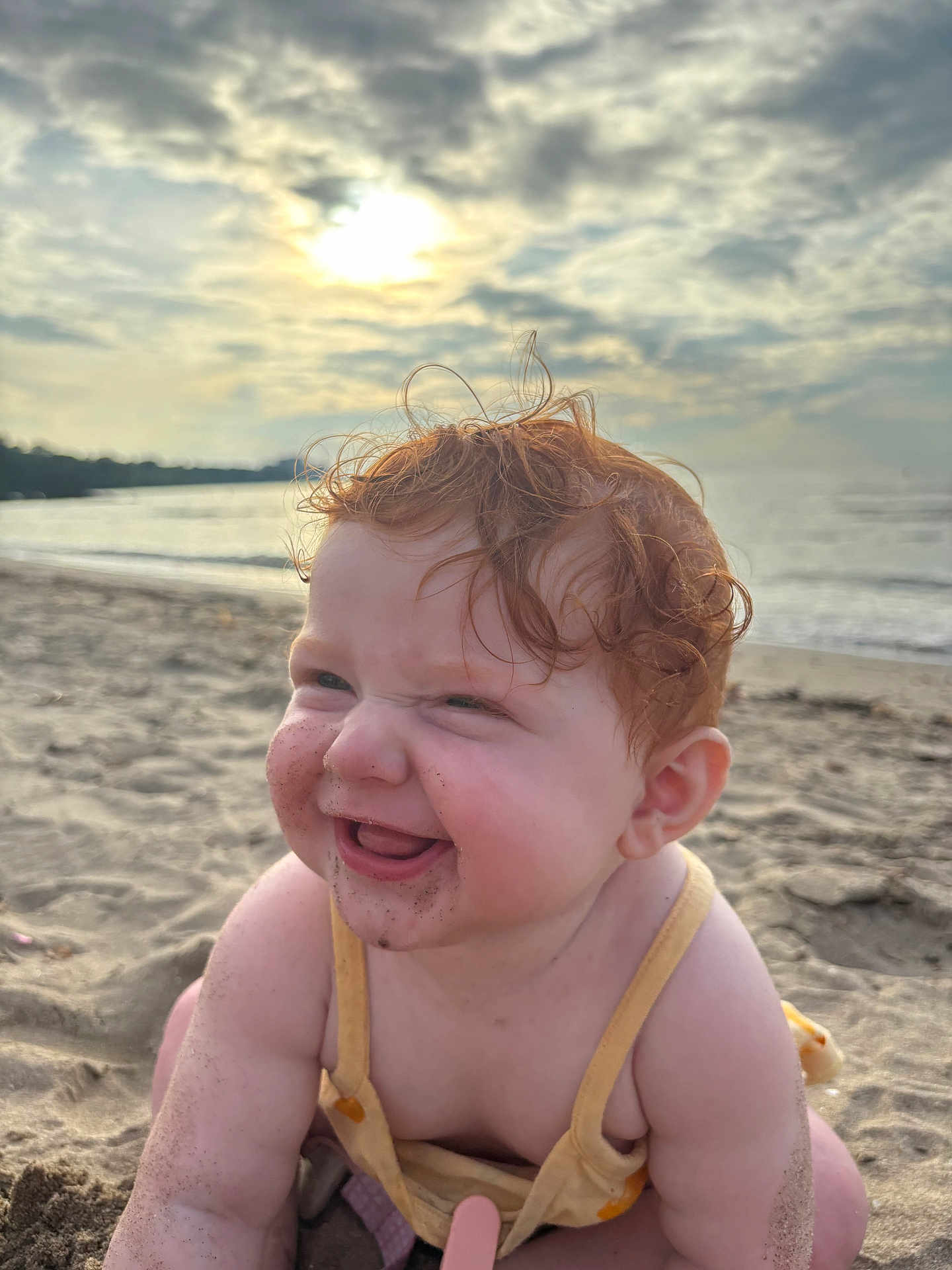Iris joined the competition — help win amazing prizes! baby, red_hair, sand, beach, smiling, happy, child, sunlight, cloudy_sky, ocean, water, nature, outdoor, cute, play, summer, skin, cheeks, tongue, crawling