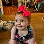 baby, child, smile, bow, headband, carpet, indoor, kitchen, chair, table, floor, person, red_hair, clothing, seat, furniture, dining_room, happy, toddler, cute