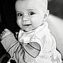 baby, child, smiling, black_and_white, portrait, infant, face, cute, apparel, striped_sleeves, bib, close_up, person, expression, happy, young, skin, head, eyes, hand