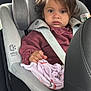 blanket, car, car_seat, child, clothing, fabric, hair, head, indoor, person, restraint, safety, seat, seat_belt, serious_expression, sitting, toddler, vehicle_interior, window, young_child