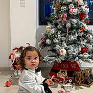 Charli a rejoint le concours — aidez-le/la à gagner de superbes lots ! black_skirt, child, christmas_tree, curly_hair, decorations, festive, floor, holiday, indoor, ornaments, pine_cones, pink_shoes, playful, sitting, tea_set, toddler, toy, toy_stroller, white_shirt, window