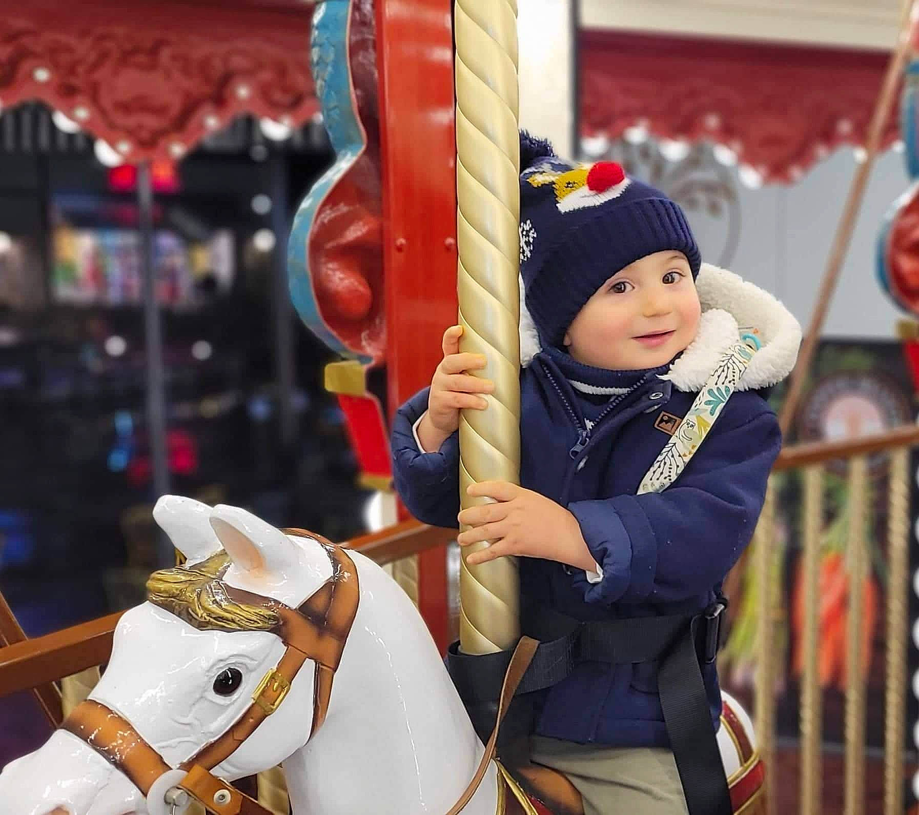 Romain participe au concours pour gagner de l'argent avec cette photo : bridle, carousel, eye, fun, happy, hat, headwear, horse, horse_supplies, horse_tack, leisure, mammal, pack_animal, people, person, photograph, playground, recreation, toddler, vertebrate