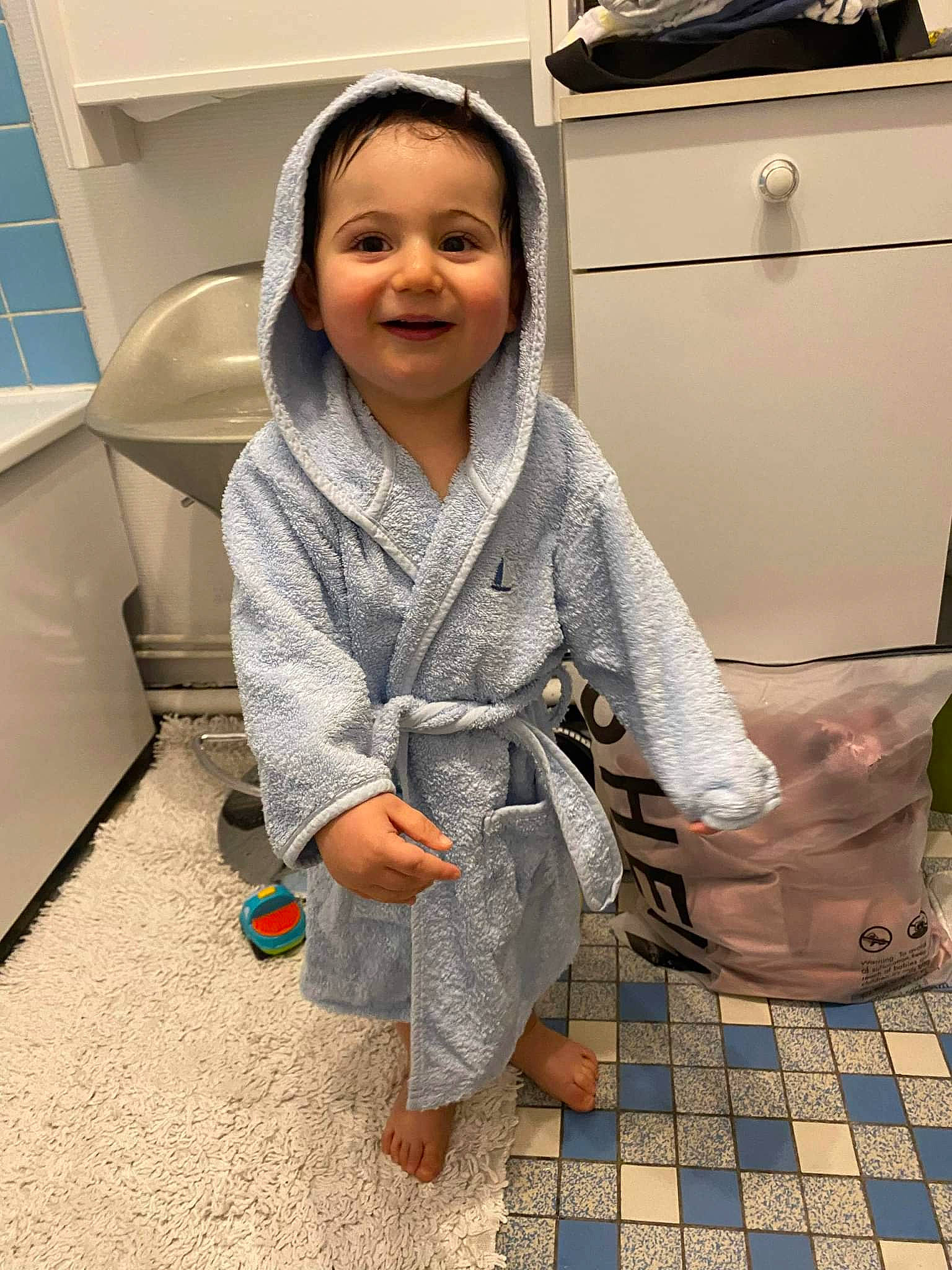 Romain a rejoint le concours — aidez-le/la à gagner de superbes lots ! baby, baby_toddler_clothing, child, comfort, floor, flooring, fun, happy, hardwood, human_leg, joy, leisure, pattern, person, product, room, sitting, sleeve, smile, standing