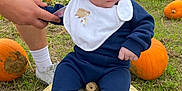 Elliot is registered to the contest to win money with this photo: baby, infant, pumpkin, pumpkin_patch, grass, outdoor, beanie, bib, socks, person, hand, orange_pumpkin, white_pumpkin, fall, autumn, nature, field, cute, child, support