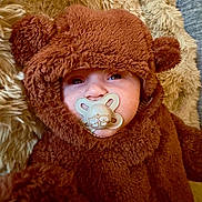 Ava Lee is registered to the contest to win money with this photo: baby, pacifier, costume, bear, fuzzy, cute, child, infant, face, ears, sucking, plush, soft, cozy, brown, clothing, portrait, lying_down, indoors, closeup