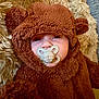 baby, pacifier, costume, bear, fuzzy, cute, child, infant, face, ears, sucking, plush, soft, cozy, brown, clothing, portrait, lying_down, indoors, closeup
