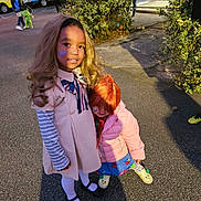 Taleah is registered to the contest to win money with this photo: child, children, costume, cute, daylight, face_paint, friendship, heart, holding, jacket, outdoor, pavement, person, playful, school_bus, shoes, street, tree, wig, young