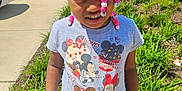 Taleah is registered to the contest to win money with this photo: beads, braids, casual_clothing, child, cute, daytime, girl, greenery, mickey_mouse, minnie_mouse, outdoor, parking_lot, plants, portrait, sidewalk, smile, standing, sunlight, tshirt, young_child