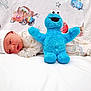 Zachary is registered to the contest to win money with this photo: newborn, baby, plush_toy, cookie_monster, blanket, cartoon, cap, pajamas, lying_down, cute, child, soft_toy, blue, white, infant, smiling_toy, bed, comfort, sleepwear, decorative